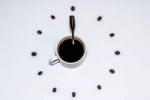 Coffee cup as dial of a clock with spoon and handles as hands of the clock.
